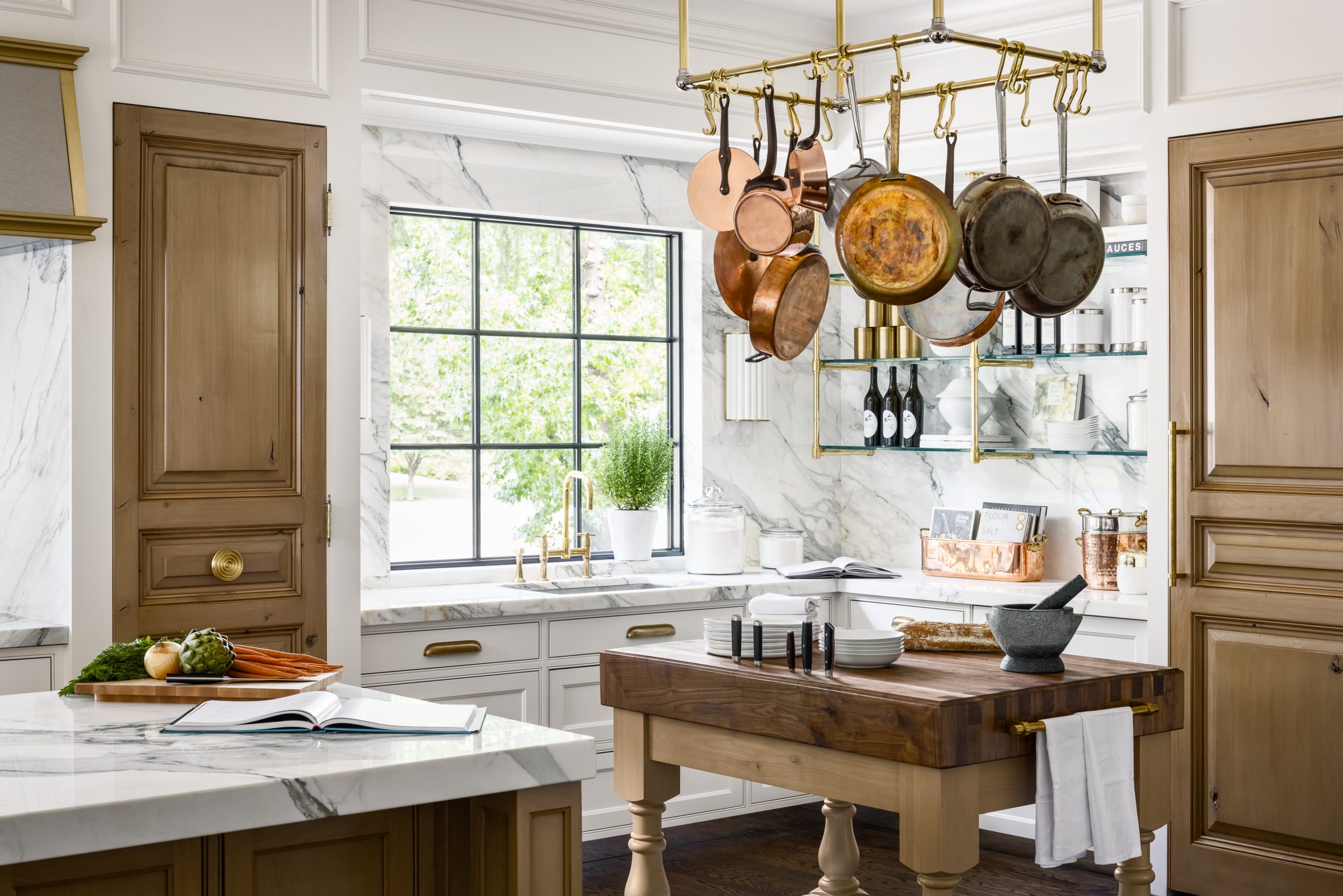 Ceiling mounted Ball style Pot Rack in polished brass with corner mounted supports in foreground ans Studio style shelving in background