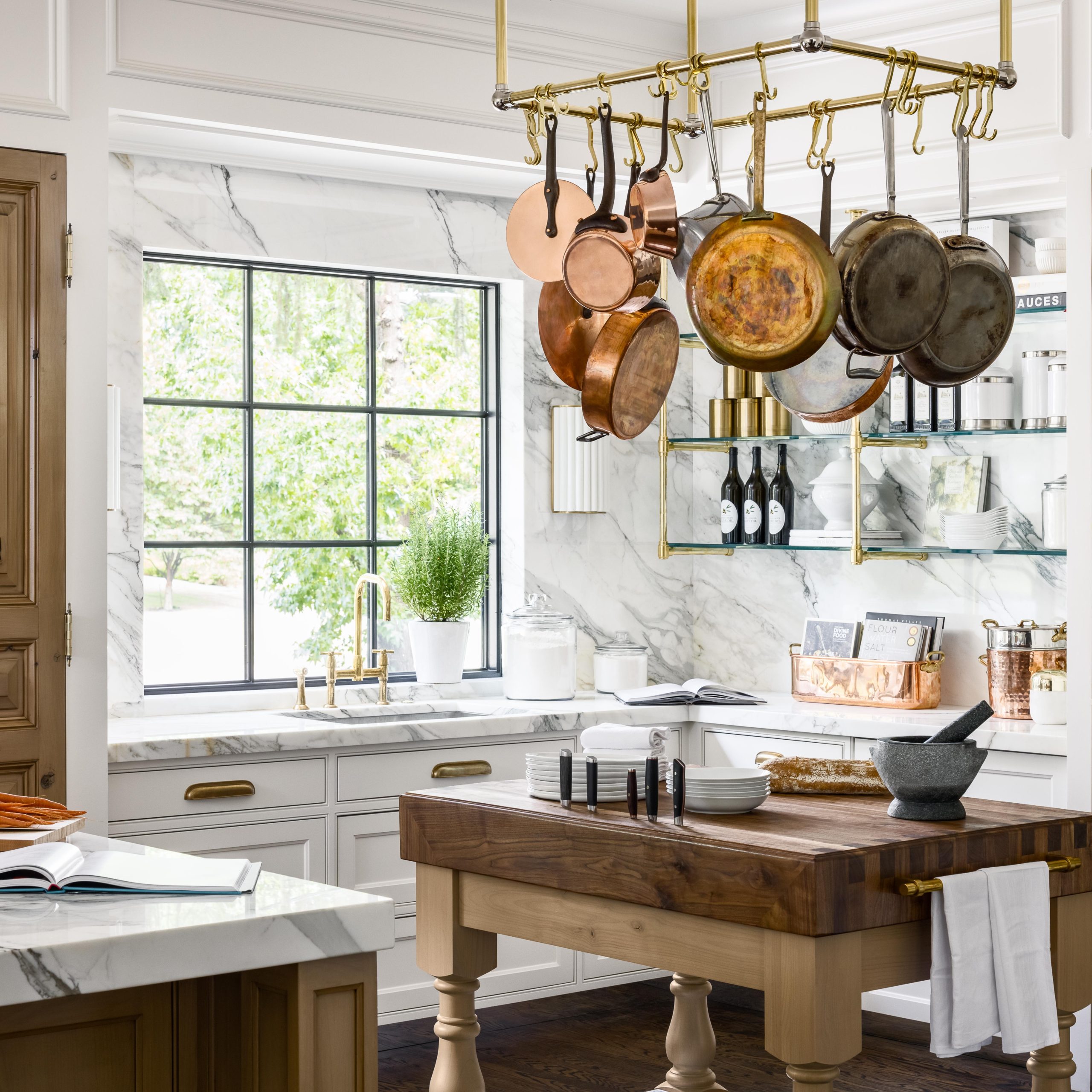 Ceiling mounted Ball style Pot Rack in polished brass with corner mounted supports in foreground ans Studio style shelving in background