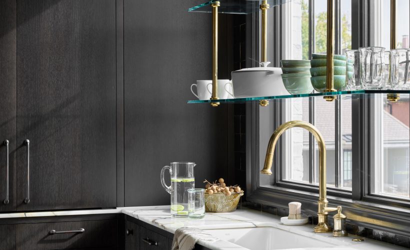 Ceiling-mounted Split Collar style Bistro Designer Shelving with Button style Finials in polished brass with glass shelves in front of a window