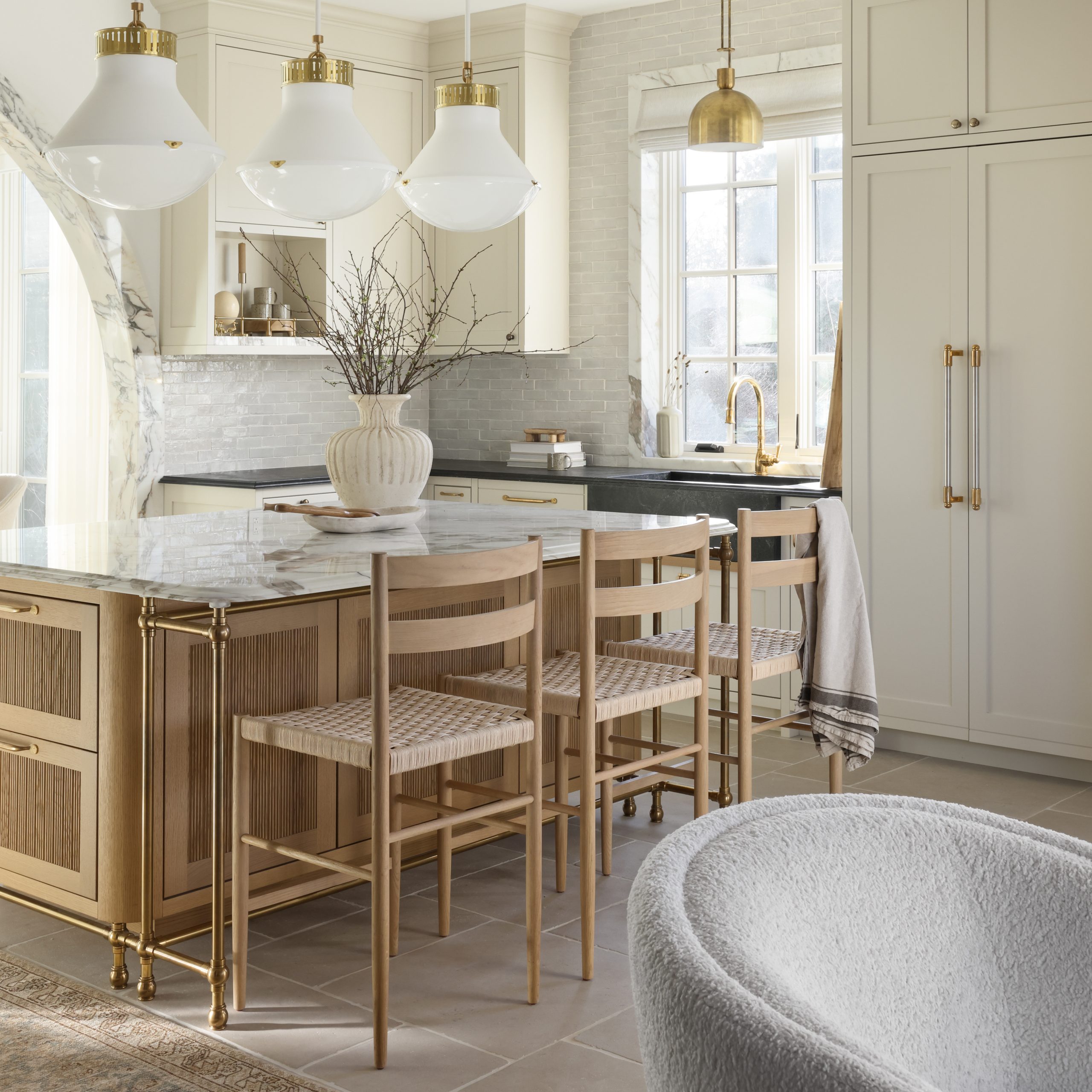 Custom Ball style Kitchen Leg System supporting a countertop overhang with integral Foot Rail in aged brass