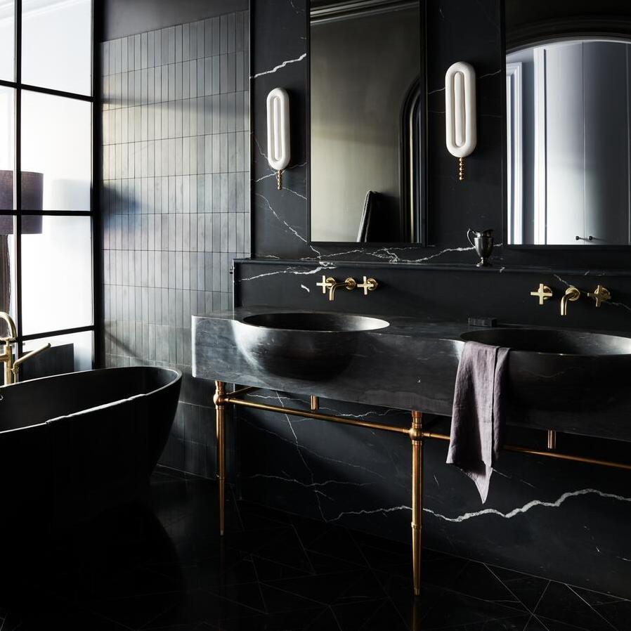 Modern style Vanity Leg System with a thick carved marble sinktop in a black themed bathroom
