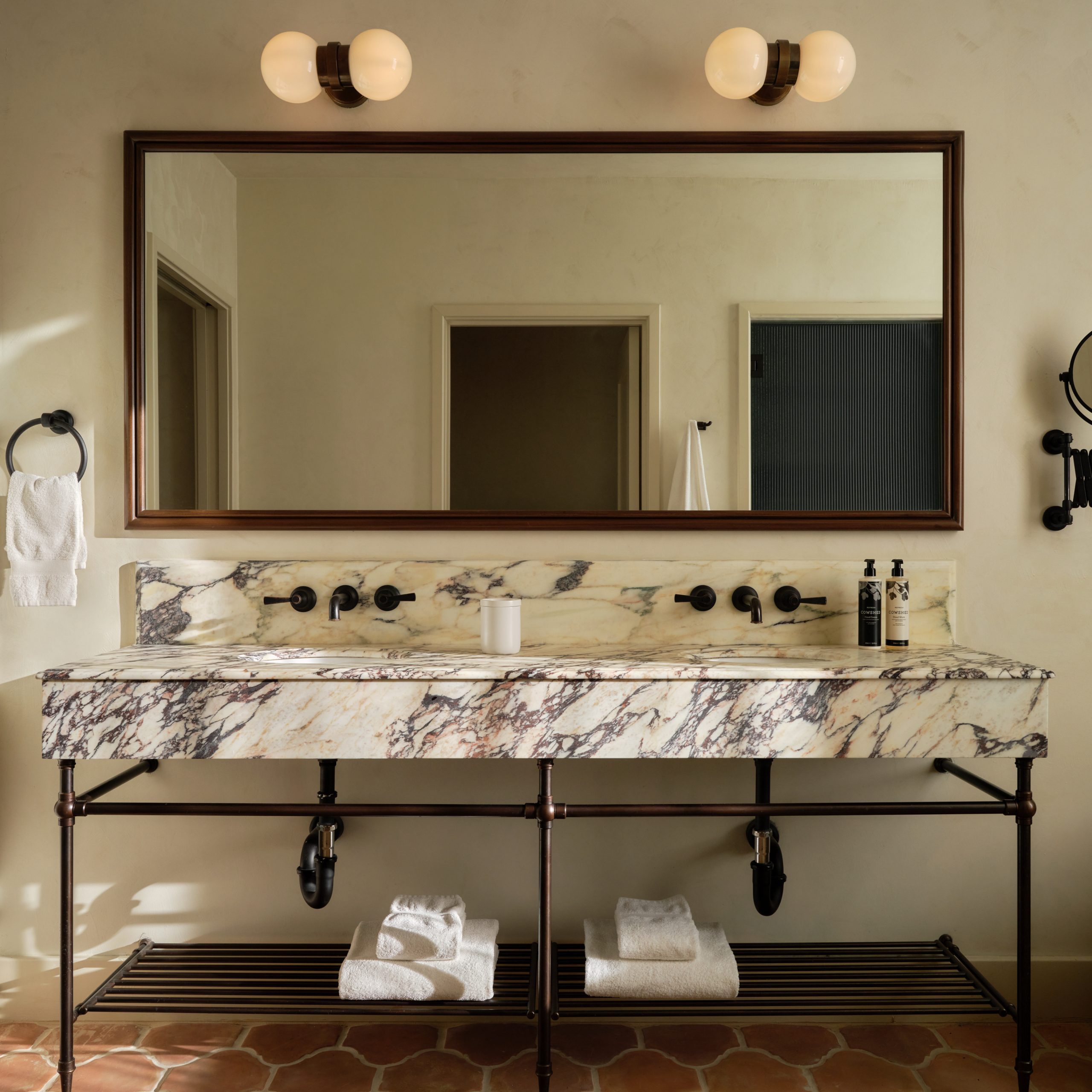 Tapered Foot style Vanity Leg System in an artisinal Oil Rubbed Bronze finish with tubular metal Hotel style shelving
