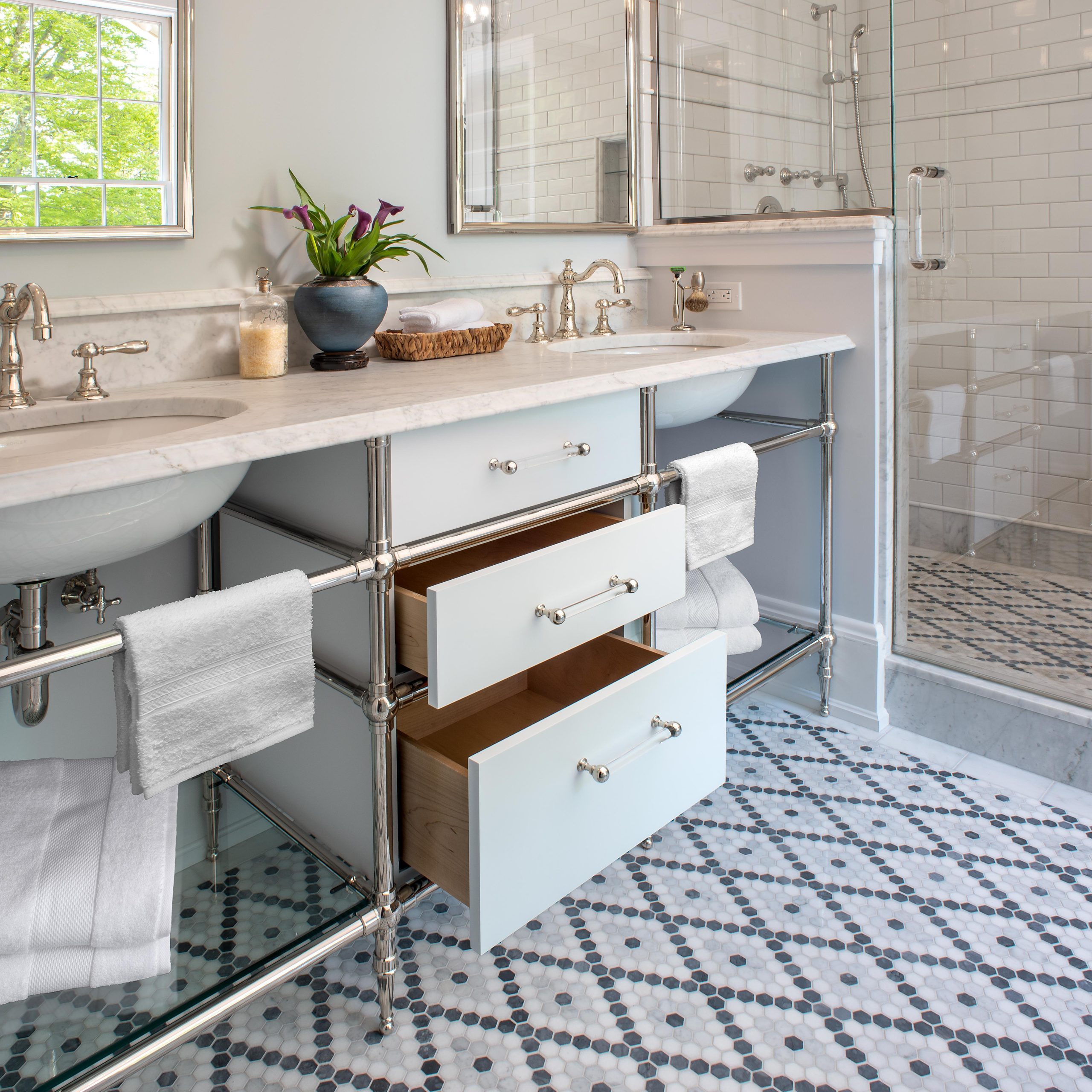 Tapered foot Vanity Washstand in polished nickel with integral drawers and glass shelves in beautiful bathroom